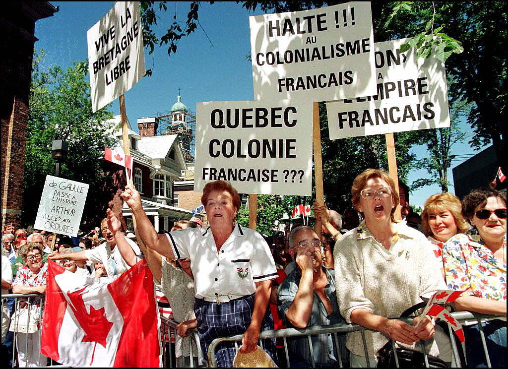 Canadians protest with signs and Canadian flags ag