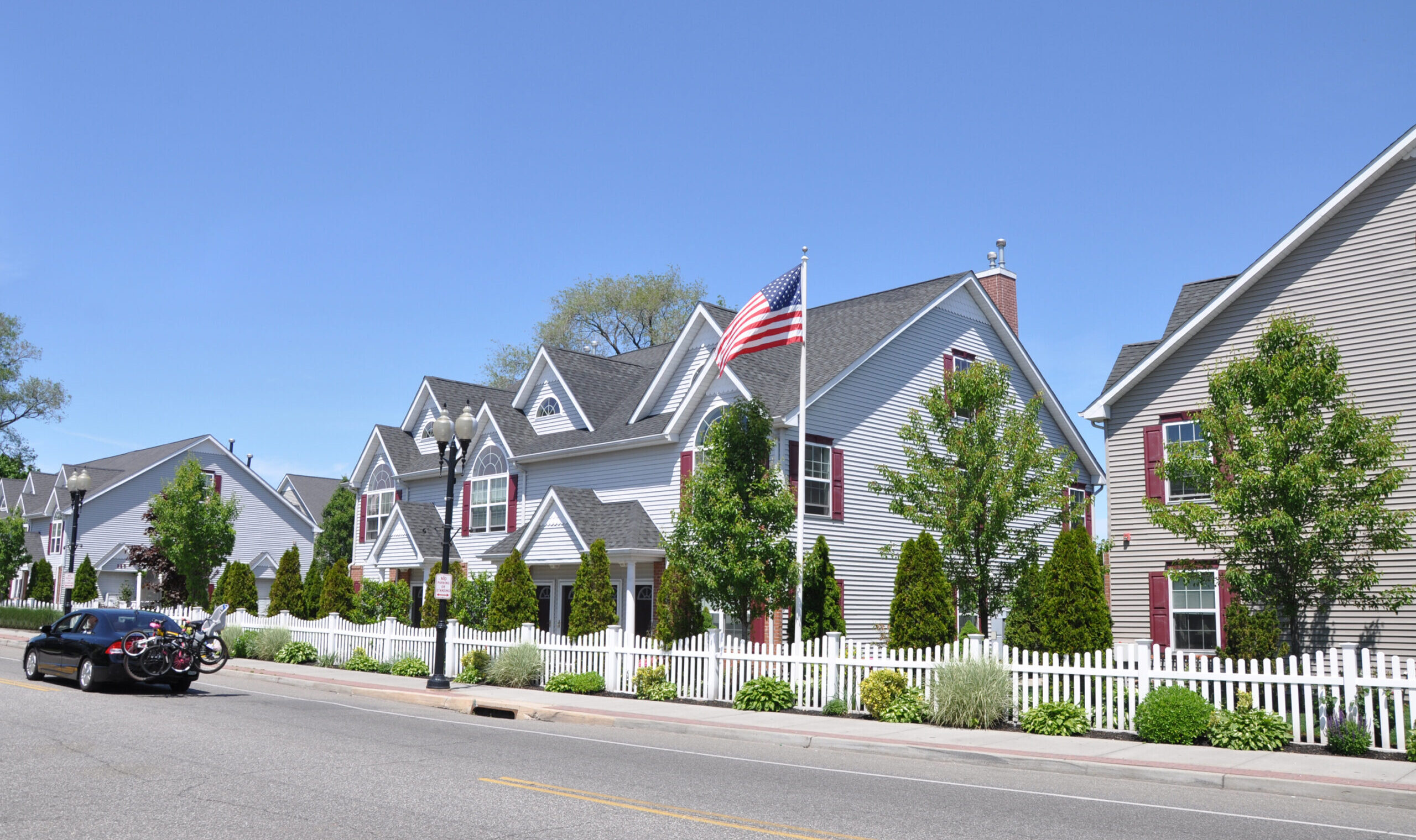 Suburban,Street,American,Flag,Row,Town,Houses,Car,Passing,With