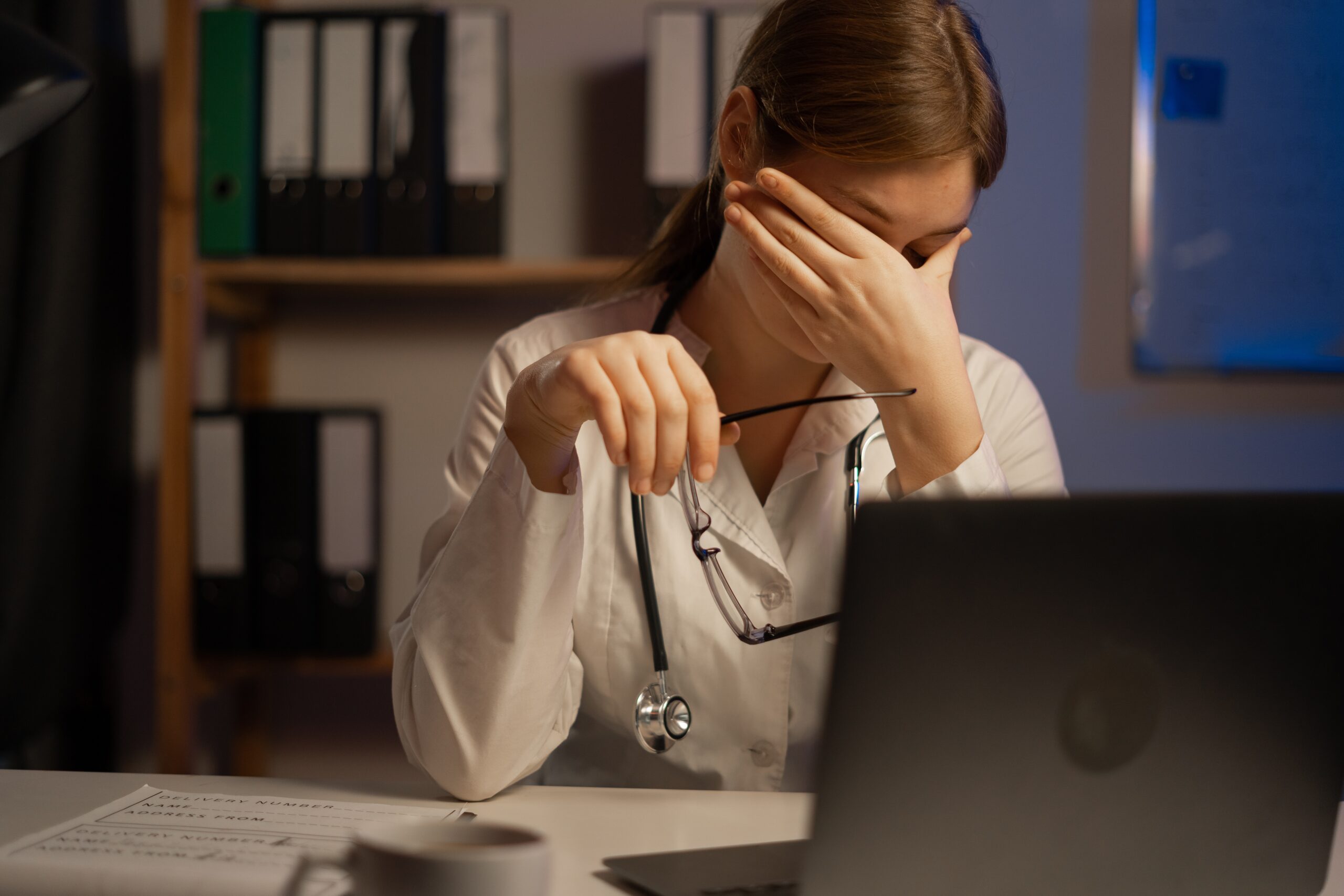 Tired,Doctor,Or,Nurse,Sitting,At,Table,During,Night,Shift.